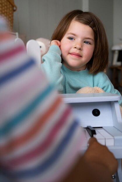 Front view little girl playing indoors