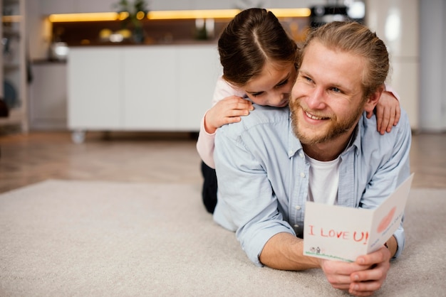 Front view of little girl spending time with father with copy space