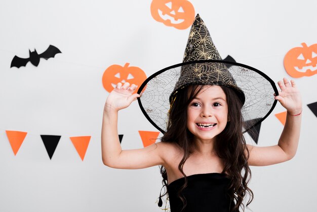 Вид спереди маленькая девочка в костюме ведьмы на Хэллоуин