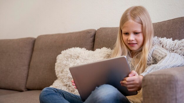 Front view of little girl with tablet