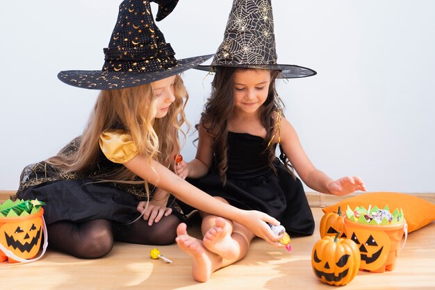 Front view little girls sitting on floor on halloween