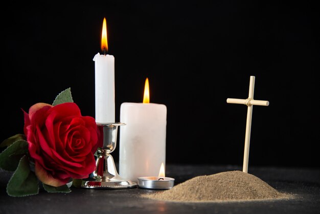 Front view of little grave with candles on black