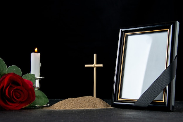 Front view of little grave with picture frame on black