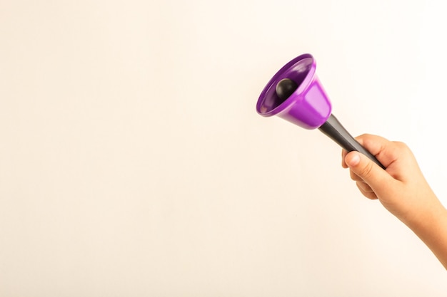 Free photo front view little kid holding purple bell on white surface