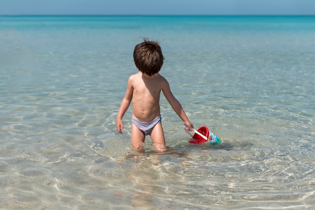 Front view of a little kid playing in water