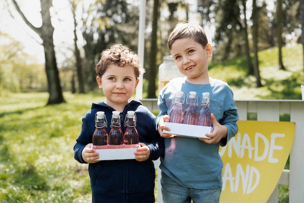 Front view little kids with lemonade