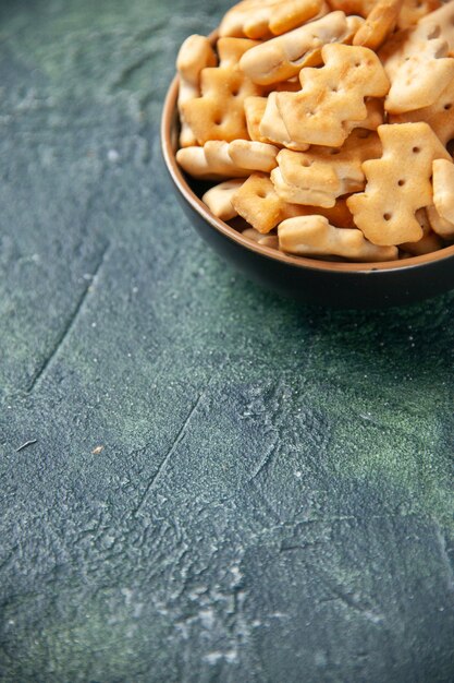 Front view little salted crackers inside plate on dark background crisp color snack cips salt pepper