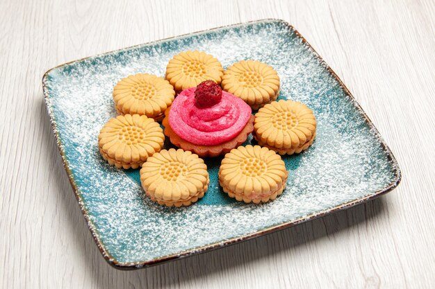 Front view little sweet cookies with fruit cake inside plate on white desk sweet biscuit cookie cake sugar tea