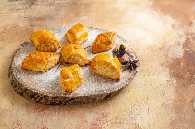 Front view little sweet pastries for tea on light desk sweet pie pastry cake