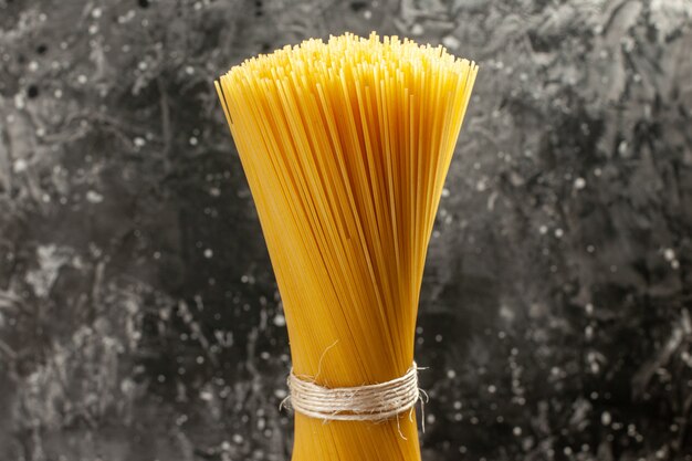 Вид спереди длинная итальянская паста сырая на светло-сером тесте пищевого цвета кухня фото еда