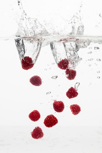 Free photo front view of lots of raspberries in water