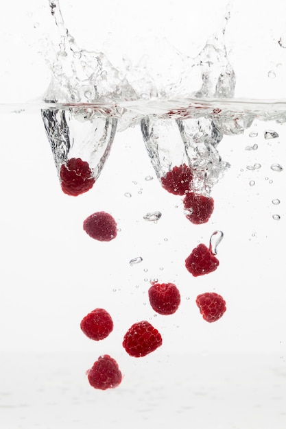 Front view of lots of raspberries in water