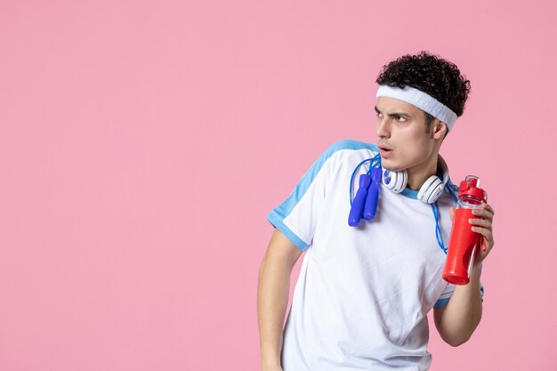 Front view male athlete in sport clothes with bottle of water