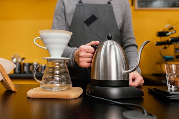 Front view of male barista holding kettle