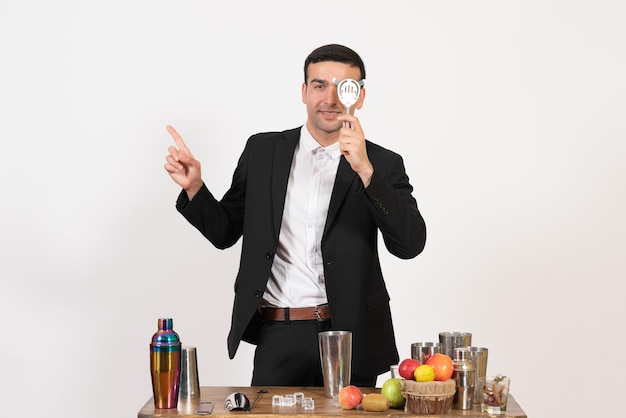 Front view male bartender in classic suit making drink on a white wall night drink club male bar dance