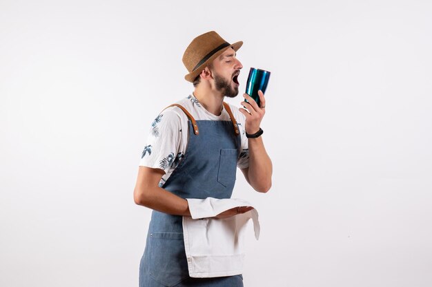 Front view male bartender cleaning shaker on the white wall club night alcohol drink job color bar