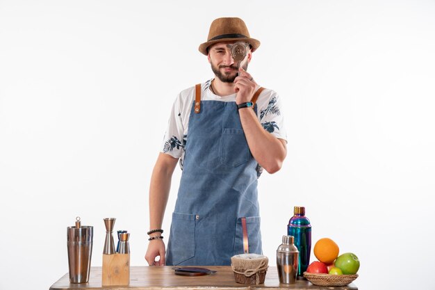 Front view male bartender holding nutcracker on light white wall job bar alcohol club night drink service