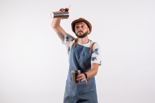 Front view male bartender holding shaker on a white wall club night bar alcohol drink job color