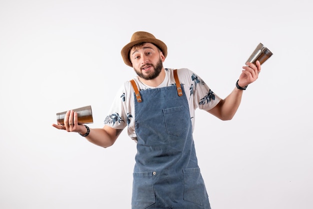 Front view male bartender holding shaker on white wall club night bar alcohol drink job color