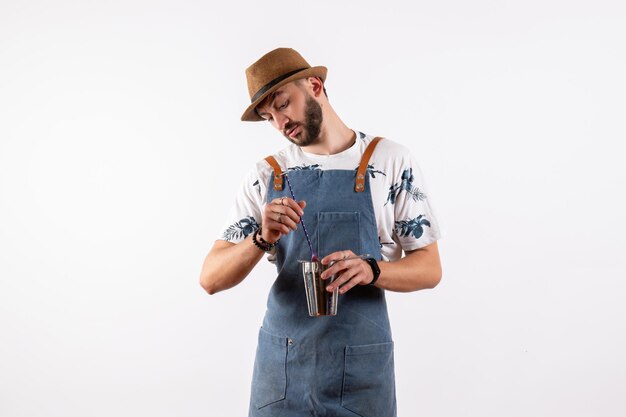 Front view male bartender holding shaker on the white wall night job club alcohol drinks color bar