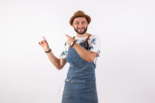 Front view male bartender pointing with smile on white wall alcohol bar club night drink job model