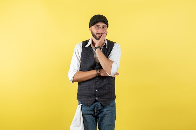 Front view male bartender posing and looking on yellow wall model drink work club male night job