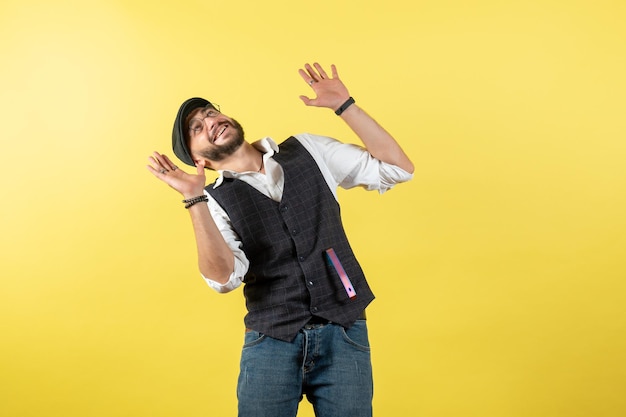 Front view male bartender smiling and looking at the ceiling on yellow wall drink job club alcohol male bar night