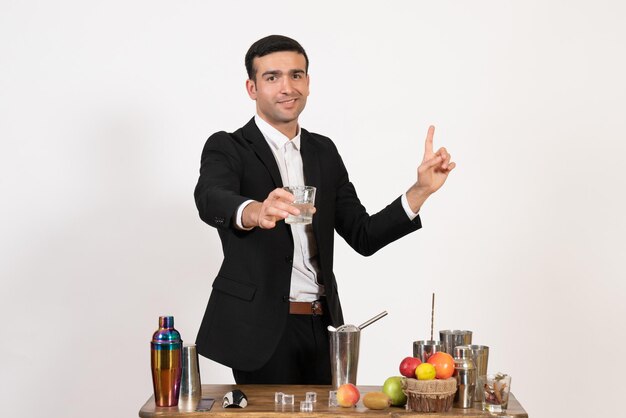 Front view male bartender in suit making drink on white wall night drink bar club male dance