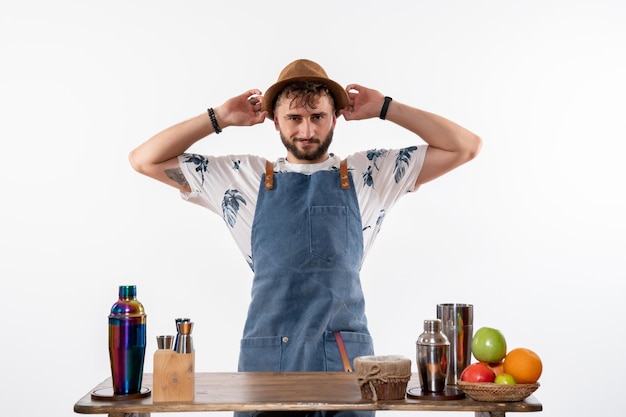 Barista maschio vista frontale che indossa il suo cappello sul muro bianco bar alcol club night drink job