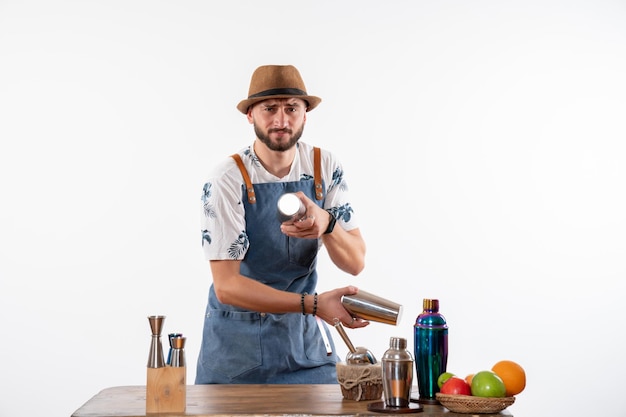 Front view male bartender working with shakers on the white wall job bar alcohol club night drink