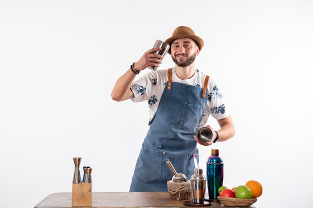 Front view male bartender working with shakers on white wall job bar alcohol club night drink