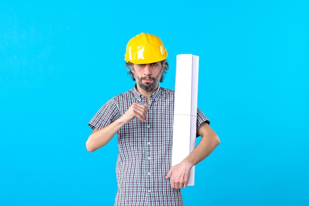 Free photo front view male builder in helmet holding plan on blue