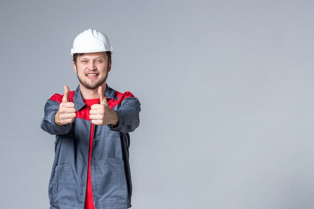 front view male builder in uniform delighted on light background