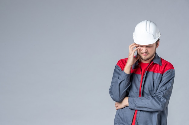 Free photo front view male builder in uniform and helmet on gray background