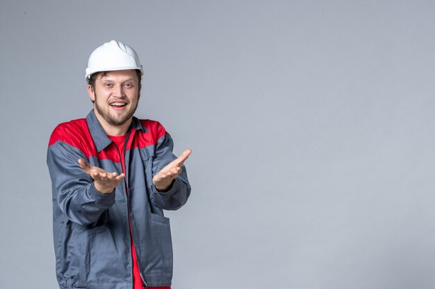 front view male builder in uniform on light background