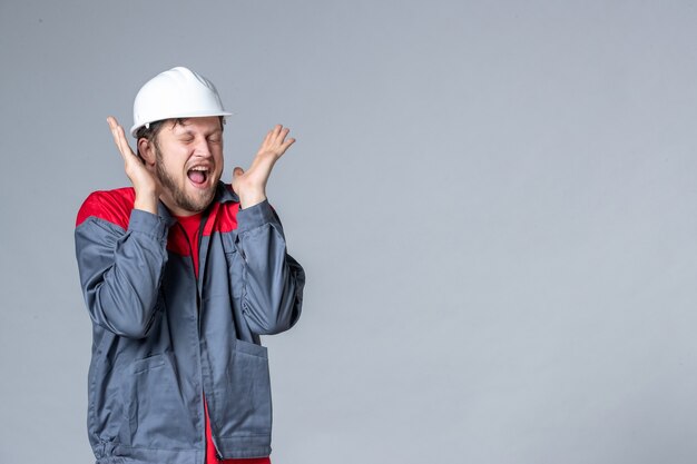 front view male builder in uniform on light background