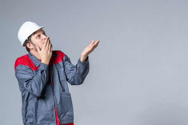 front view male builder in uniform on light background