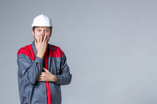 front view male builder in uniform on light background