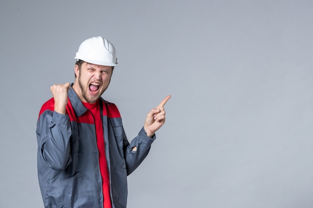 front view male builder in uniform rejoicing emotionally on light background
