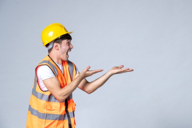 front view of male builder in uniform on white wall