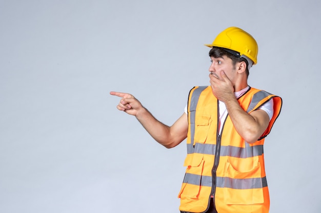 вид спереди мужчины-строителя в униформе на белой стене