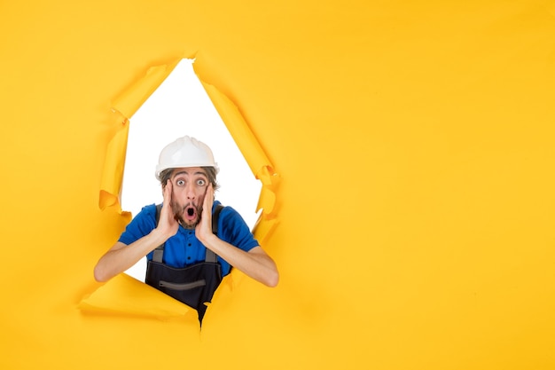 Free photo front view male builder in uniform on the yellow background