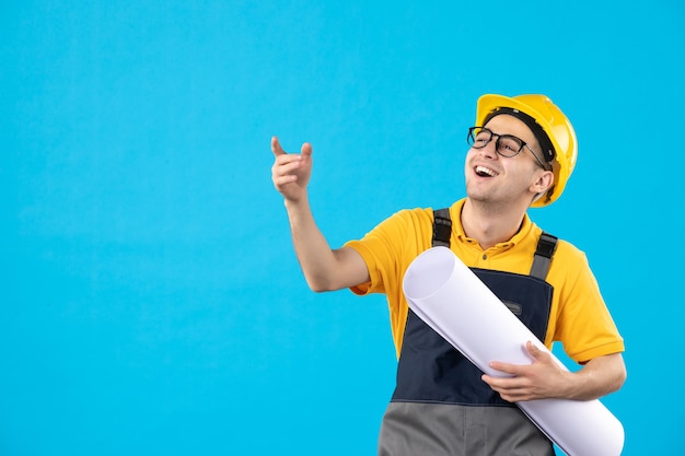 Free photo front view of male builder in yellow uniform with plan blue