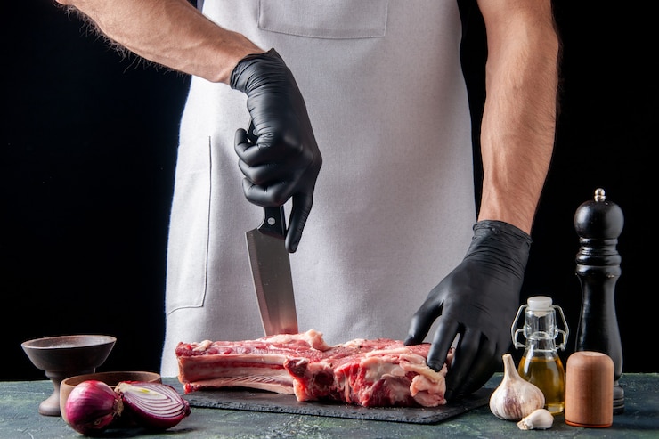 Free Photo front view male butcher cutting meat on a dark surface