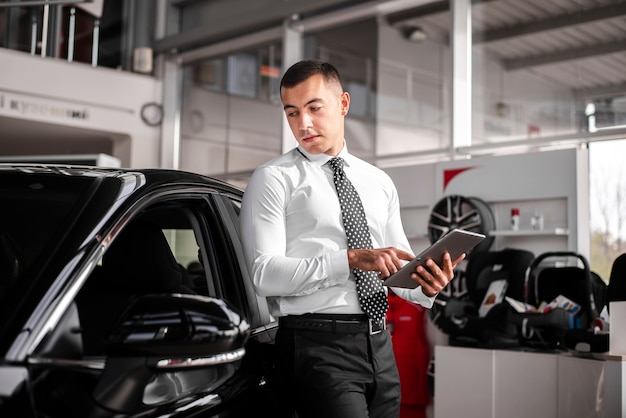 Front view male car dealer with tablet