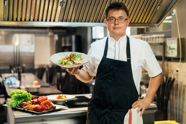 Free photo front view of male chef holding dish