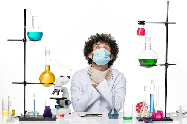 Front view male chemist in medical suit and with mask chocking himself on white space