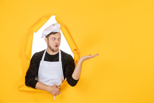 Front view male cook in white cape and cap on yellow ripped food job white kitchen man cuisine photo colors