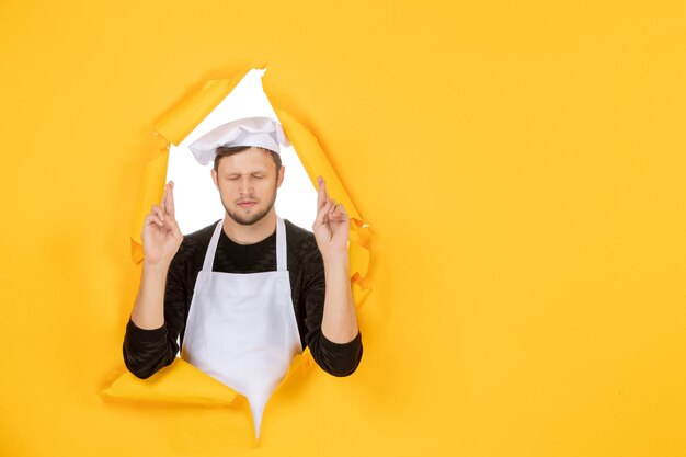 Foto gratuita cuoco maschio di vista frontale in mantello bianco e berretto sul lavoro strappato giallo colore bianco foto cibo uomo cucina