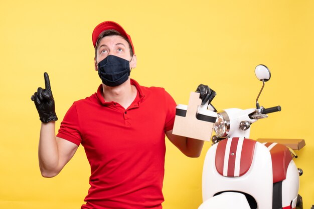 Front view male courier in black mask with coffee cups on yellow worker virus